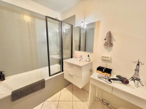a bathroom with a tub and a sink and a shower at Duplex à proximité de la place Stanislas in Heillecourt