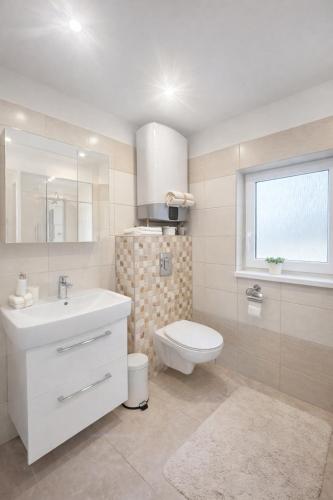 a bathroom with a sink and a toilet and a window at Chaloupka v ráji in Veselá
