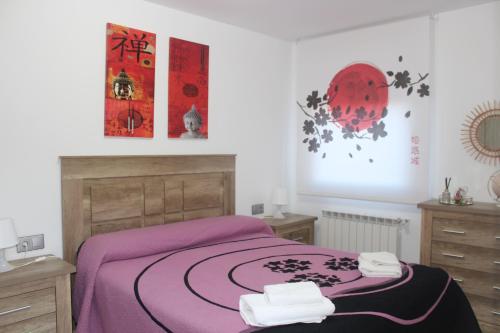 a bedroom with a purple bed with two towels on it at LA OKIYA DE TATI in Zamora