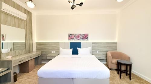a bedroom with a bed and a desk and a chair at سديم الفخر 2 للشقق الفندقية in Taif