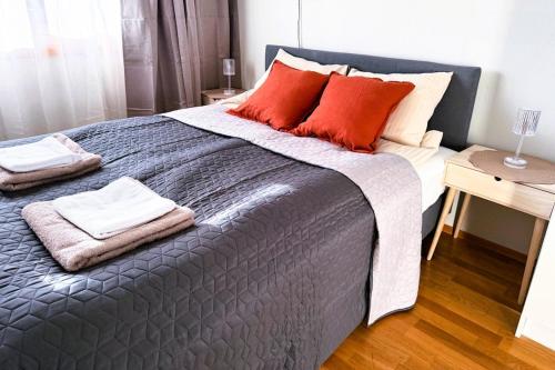 a bedroom with a large bed with red pillows at Nordic Comfort Apartment in Trondheim