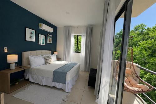 a bedroom with a bed and a balcony at Resort living Selva Escondida II in Puerto Morelos