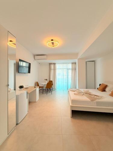 a bedroom with a bed and a desk and a kitchen at Amira Residence in Eforie Nord