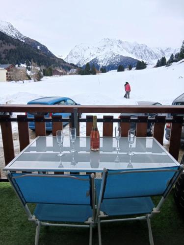 a table with glasses and a bottle of wine at Studio en station de ski familiale, vue sur les montagnes in La Morte