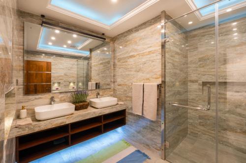 a bathroom with two sinks and a shower at Lasantha's Residence in Kadawata