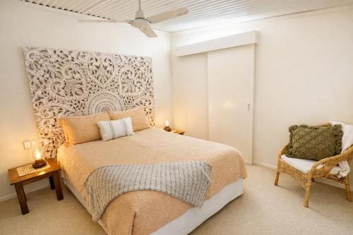 a bedroom with a large bed and a chair at Taman Sari Sunshine Coast Romantic Pet-Friendly Hinterland Retreat in Mapleton