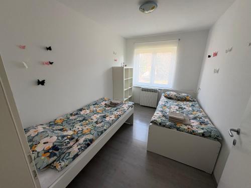 a bedroom with two beds and a window at Apartma S in Sežana