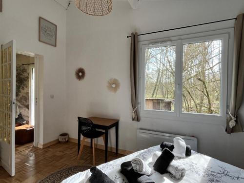 a bedroom with a bed and a window and a desk at Cabercé Thoiré in Thoiré-sur-Dinan