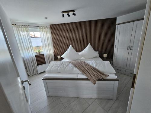 a bedroom with a bed with white sheets and pillows at Ferienhaus Meeresbrise in Wurster Nordseeküste
