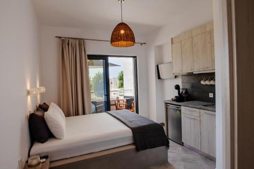 a bedroom with a bed and a kitchen with a balcony at Aethrèa Apartments in Haraki
