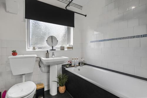 a bathroom with a toilet and a sink and a bath tub at 2BR Apartment Free Parking Sleeps 4 Cheltenham in Cheltenham