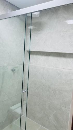 a glass shower door in a bathroom at Hotel MM AEROPORTO BRASÍLIA in Núcleo Bandeirante