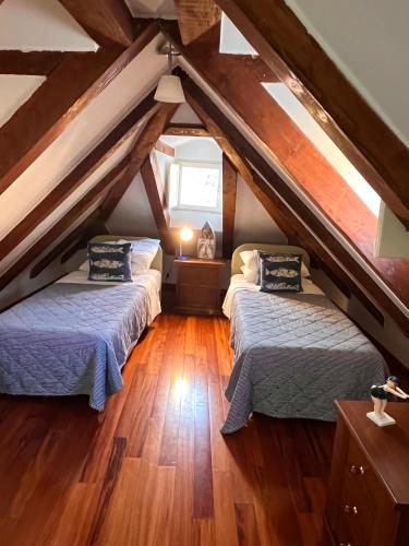 two beds in a attic room with wooden floors at 22 THE STRADUN in Dubrovnik