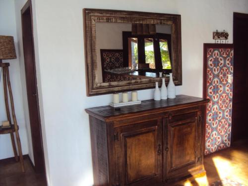 フレシェイラスにあるVillas de Guajirú, Casa 1の木造のキャビネットの横の壁面鏡