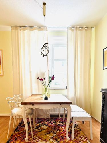 a dining room table with a vase of flowers on it at KÜCHWALDBLICK Designsuite in Chemnitz