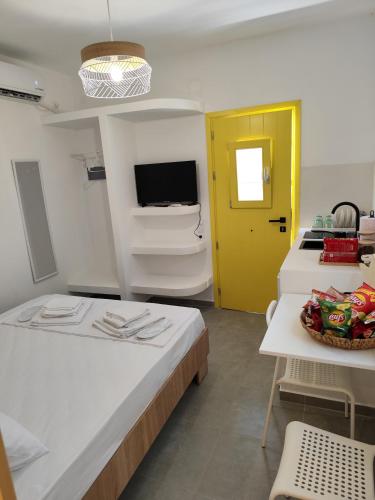 a room with two beds and a yellow door at Ventalia in Kimolos