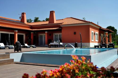 a house with a swimming pool in front of a house at Monte d'Alto in Santo Estêvão