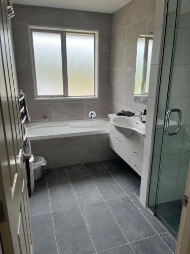 ein Badezimmer mit Badewanne und Waschbecken in der Unterkunft Shinness in Ashwick Flat