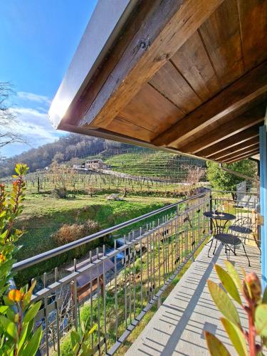 a balcony with a table and a view of a field at Lambo Cellini - Bed & Breakfast in Valdobbiadene
