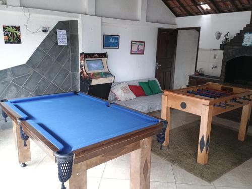 a room with a ping pong table and a video game at Pousada Renascer in Mangaratiba