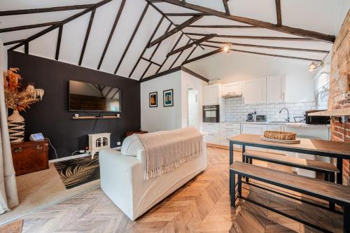 a living room with a couch and a table at New Forest Cottage with Hot Tub, Fireplace and Private Garden in Cadnam