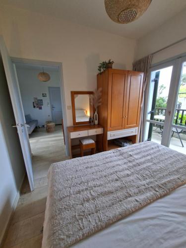 a bedroom with a bed and a dresser and a mirror at Elysian Garden in Kalyves