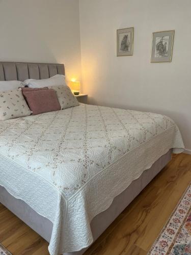 a bedroom with a bed with a white comforter at Ferienwohnung Blerta in Gerolstein