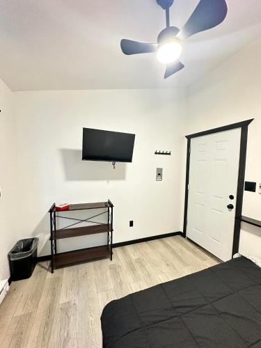a bedroom with a ceiling fan and a tv on the wall at Camo Getaway Cabin #7 in Houston