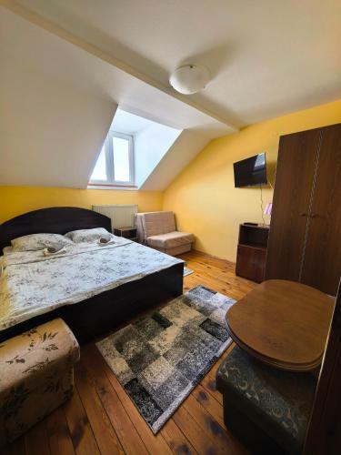 a bedroom with a large bed and a table at Apartmani Vita in Divčibare
