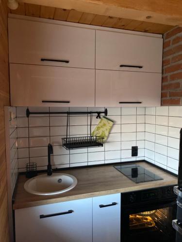a kitchen with a sink and white tiled wall at Brvnara Zoja - Zlatar in Prorečane