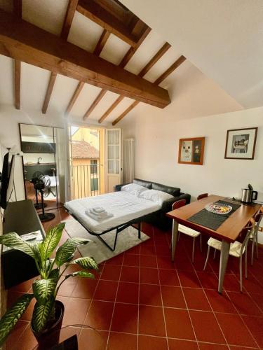 a living room with a bed and a table at La Dolce Imola-Bilocale in centro storico in Imola