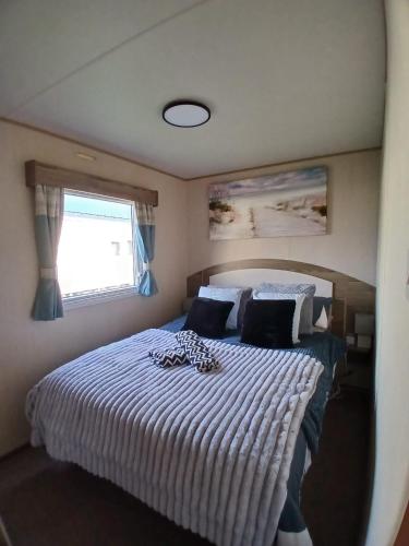 a bedroom with a bed with a white comforter and a window at Seaton Sands 71 Aberlady in Port Seton