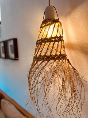 a light hanging from a wall with a bunch of branches at Finca W - Coín - Málaga - Andalucía in Coín