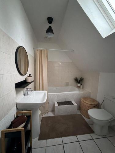 a bathroom with a sink and a toilet and a tub at Appartement Maisonnette pour 4 personnes in La Ferté-Vidame