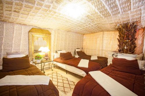 a bedroom with four beds in a room with a ceiling at Riad Dar Sofian in Zagora