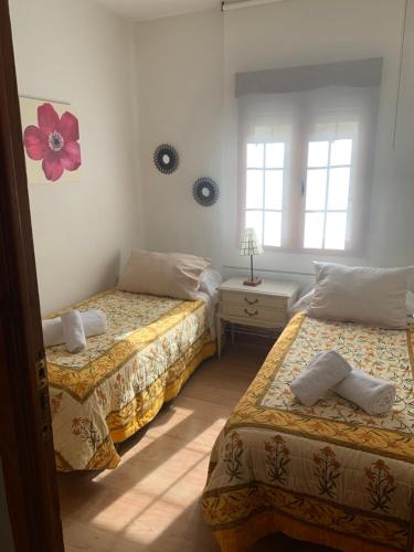 two beds in a room with two windows at El balcón de Araceli in Cercedilla