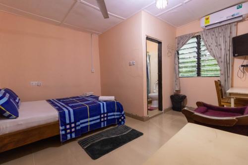 a bedroom with a bed and a chair in it at Wli Waterfalls Inn,My Home Your Home in Wli Afegame
