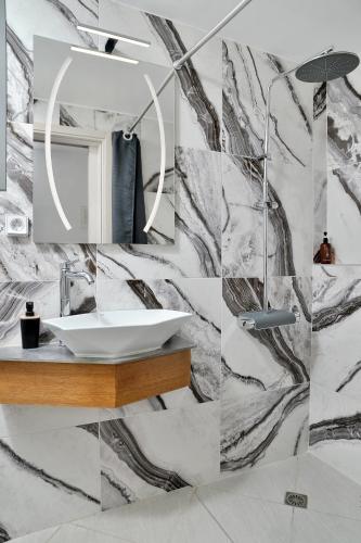 a bathroom with a sink and a mirror at SunDay Free Airport Shuttle in Artemida