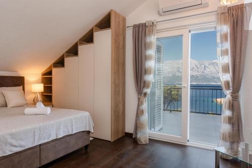 a bedroom with a bed and a large window at Villa Maris in Povlja