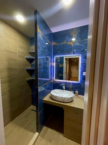 a bathroom with a sink and a blue tiled wall at Well House Cozy 2BR in Tbilisi City