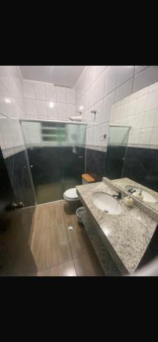 a bathroom with a sink and a toilet at Residêncial Allah in Peruíbe