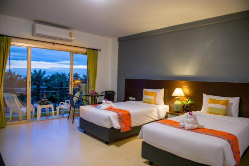 a hotel room with two beds and a balcony at Z-Talay House in Klong Muang Beach