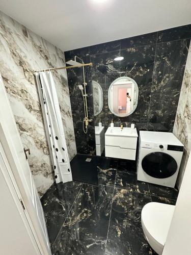 a bathroom with a toilet and a sink and a mirror at Sara Home in Baia Mare