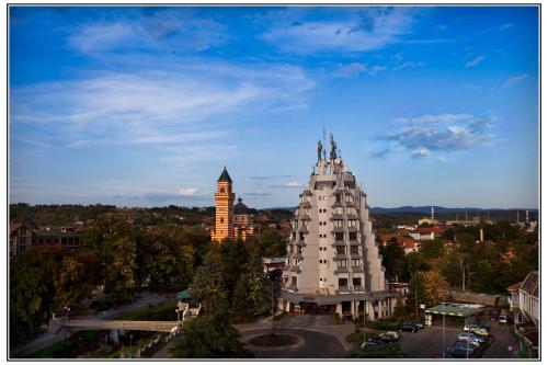 a large white building with a city in the background at Hotel Petrus in Paraćin