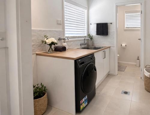 a small kitchen with a sink and a dishwasher at Pandora Place in Lightning Ridge