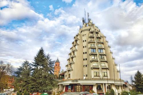 a tall building with a tower on top of it at Hotel Petrus in Paraćin