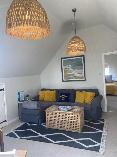 a living room with a blue couch and a table at The Nookery in Winscombe
