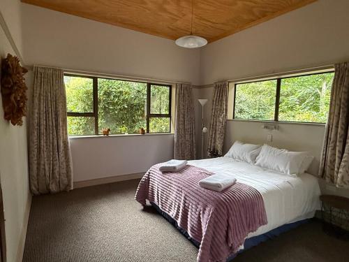 a bedroom with a bed with two towels on it at Rakanui Hidden Retreat in Hilderthorpe