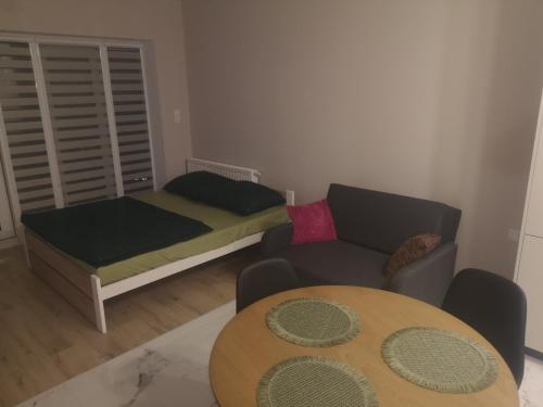 a small living room with a bed and a table at Nocleg Zagnańska in Kielce