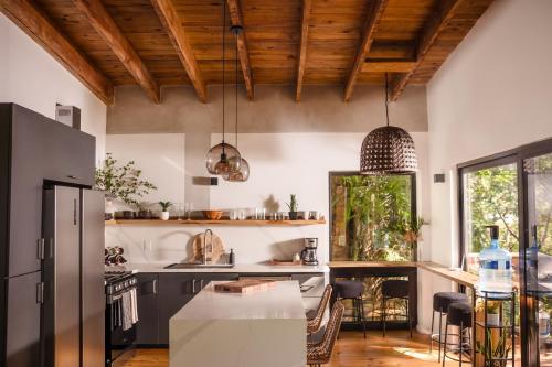 a kitchen with wooden ceilings and a table with chairs at Villa Sea Breeze in West End